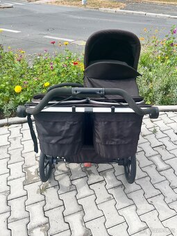 Pohled zezadu na rukojeť a úložné kapsy dvojkočárku